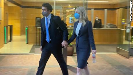 Elizabeth Holmes leaves a San Jose courtroom with her partner after her first testimony.