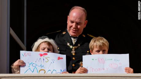 Princess Gabriella and Prince Jacques hold signs for their mother on the balcony of Monaco Palace during celebrations marking Independence Day.