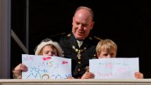 Princess Gabriella and Prince Jacques hold signs for their mother on the balcony of the the Monaco Palace during ceremonies marking National Day.