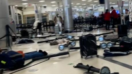 A still image taken from a video shared by a witness shows airport stanchions knocked over where passengers were previously waiting in line.