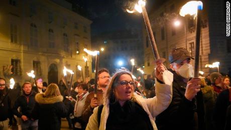 Anti-lockdown protesters hold torches in Vienna, Austria on Saturday.