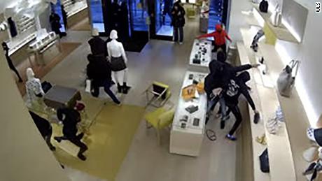 A polícia diz que 14 pessoas correram para uma loja Louis Vuitton nos arredores de Chicago e saíram com pelo menos US $ 100.000 em mercadorias.