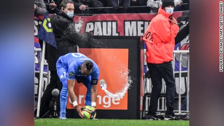 Dimitri Payet is hit by a bottle of water from the stands during the match between Lyon and Marseille.