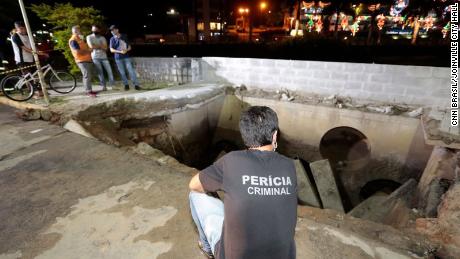 Officials survey the scene after a sidewalk collapsed in the city of Joinville on Monday. 
