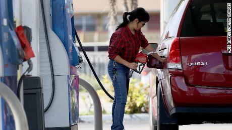 A customer pumps gas into her vehicle at a gas station on November 22, 2021 in Miami, Florida. 