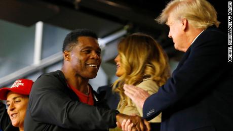 Former football player and political candidate Herschel Walker interacts with former president of the United States Donald Trump prior to Game Four of the World Series between the Houston Astros and the Atlanta Braves Truist Park on October 30 in Atlanta, Georgia. 