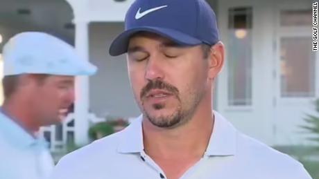 Koepka rolls his eyes and loses his train of thought as DeChambeau walks behind him at the 2021 PGA Championship. 