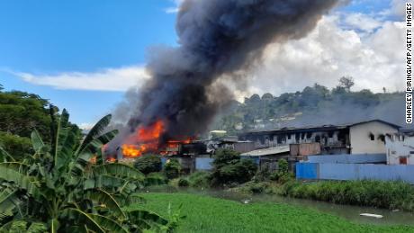 Flames rise from buildings in Honiara&#39;s Chinatown on November 26, following days of unrest