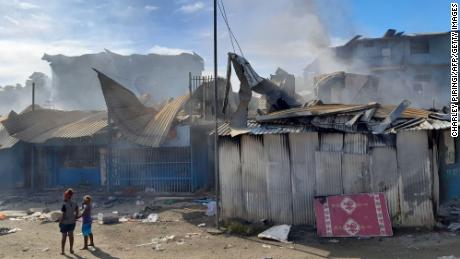 Smoke rises from burned-out buildings in Honiara&#39;s Chinatown on November 26.