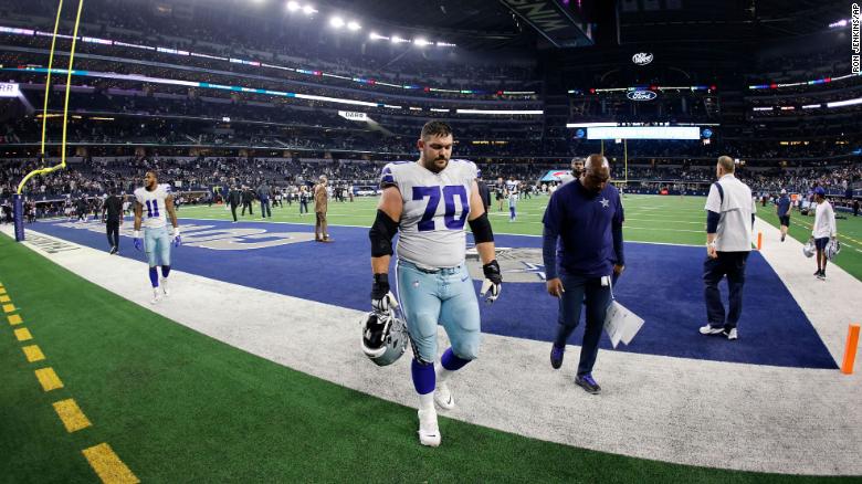The Dallas Cowboys&#39; Zack Martin and Micah Parsons walk off the field after losing against the Las Vegas Raiders.