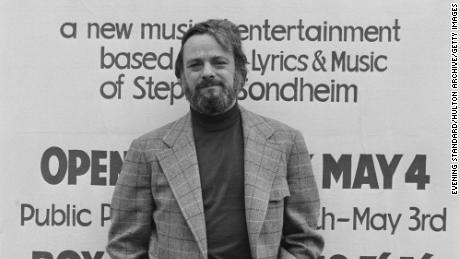 Stephen Sondheim poses in front of a poster for 'Side by Side by Sondheim' opening on May 4, 1976 at the Mermaid Theater in London, England, April 1976.