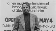 American composer and lyricist Stephen Sondheim poses in front of a poster for &#39;Side by Side by Sondheim,&#39; opening on 4 May 1976 at the Mermaid Theatre in London, England, April 1976. (Photo by Evening Standard/Hulton Archive/Getty Images)
