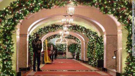 A Marine White House Military social aide stands at attention in a hallway of the White House during a press preview of the White House holiday decorations.
