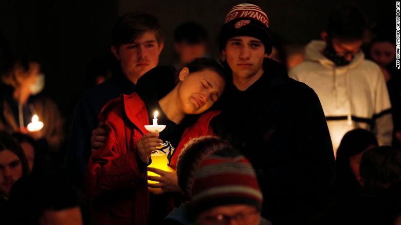 Students hold candles during a vigil after a shooting Tuesday at Oxford High School in Michigan. 