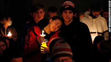 A person becomes emotional as students holding candles are asked to stand during a vigil after a shooting at Oxford High School at Lake Pointe Community Church in Lake Orion, Michigan, on November 30, 2021. 