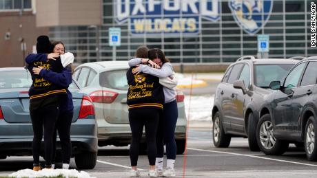 Students hug at outside Oxford High School in Oxford, Mich., Wednesday, December 1, 2021. 