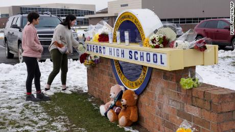 Students leave flowers at the Oxford High School sign where memorabilia is located in Oxford, Michigan, on December 1, 2021. 