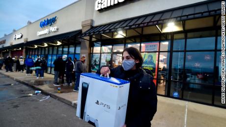 A buyer is leaving GameStop with the new Play Station 5 game console during Black Friday on November 27, 2020. 