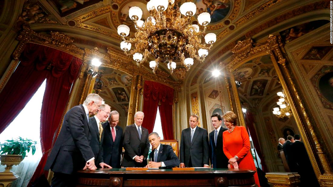 Reid, far left, and other lawmakers from both parties surround President Barack Obama as he signs a proclamation commemorating his inauguration in 2013.