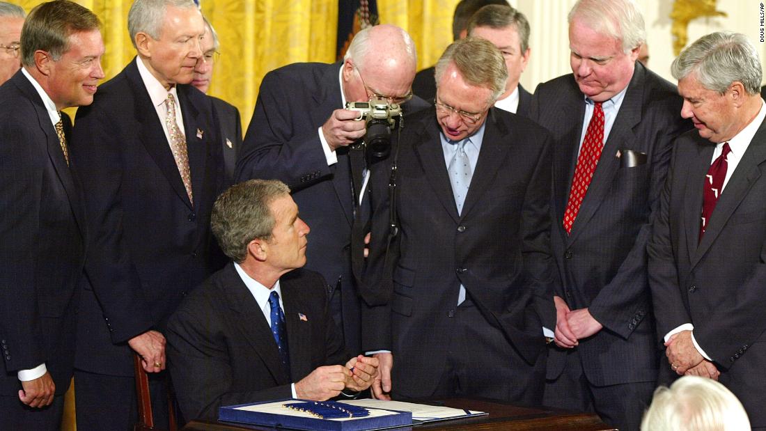Reid stands next to US Sen. Patrick Leahy as he takes a photo of President George W. Bush signing an anti-terrorism bill in 2001. It was six weeks after the September 11 attacks.