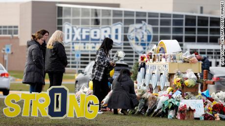 People gather at the memorial for the dead and wounded outside of Oxford High School in Oxford, Michigan, on December 3, 2021. 