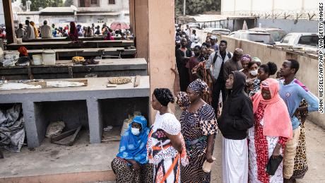 People wait in line ahead of the opening of a voting station in a market in the Manjai Kunda neighborhood in Banjul, Gambia on November 4, 2021. 