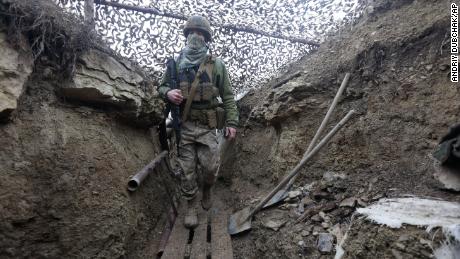 Ukrainian soldiers walk under a camouflage net in a trench on the line of separation from pro-Russian rebels near Debaltsevo, Donetsk region, in Ukraine on Friday.