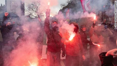Protesters light flares as leftwing political groups gather to protest Sunday against Zemmour&#39;s entrance into the French presidential election.