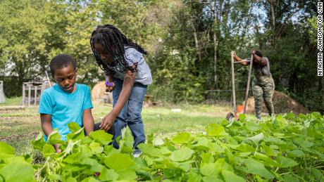 Tiffany Washington, right, works at her farm with her son Boston Zanders, 7, left, and  daughter Raeghan Zanders, 8.