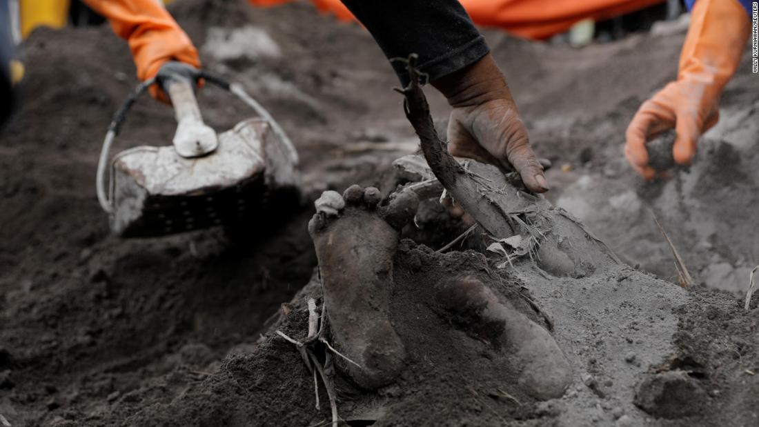 A victim&#39;s foot is uncovered by rescue workers on Monday.