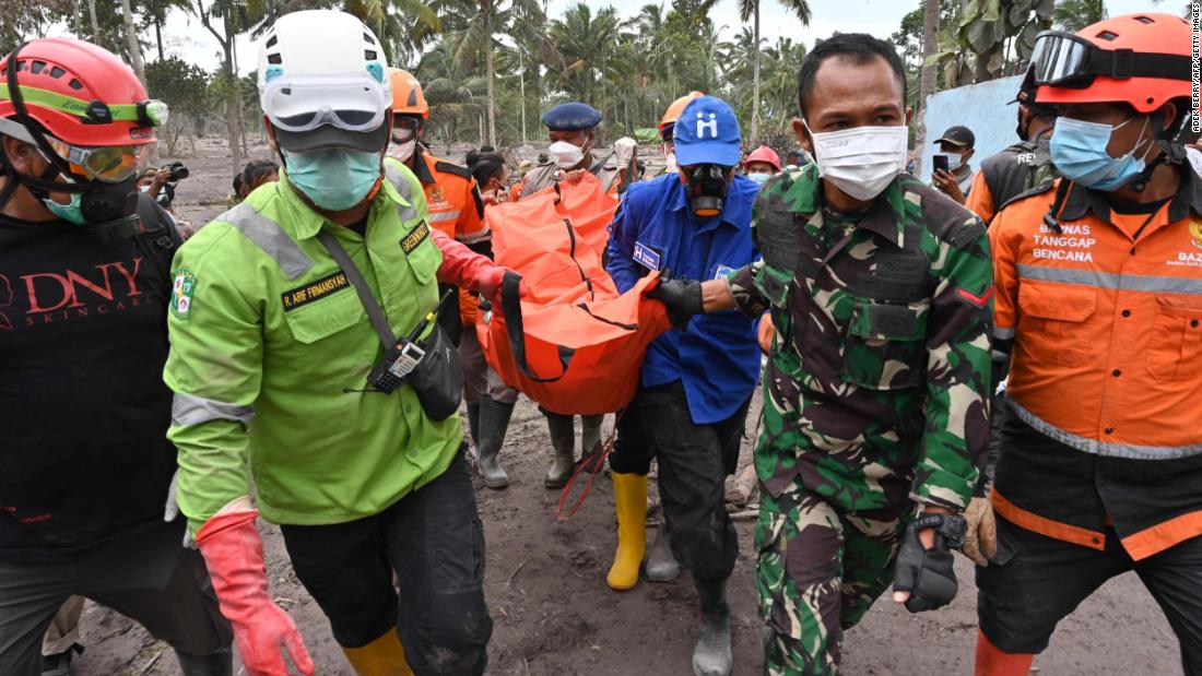 Members of a search-and-rescue team carry a dead body at the Sumberwuluh village on Monday.