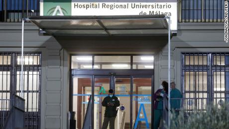 Healthcare workers stand at the front entrance of the Malaga Regional University Hospital, in Malaga, southern Spain, December 6, 2021.
