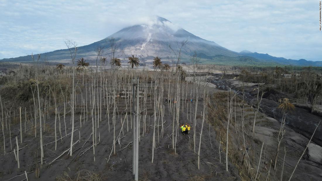 Rescue volunteers carry a body bag in Curah Kobokan, Pronojiwo district. 