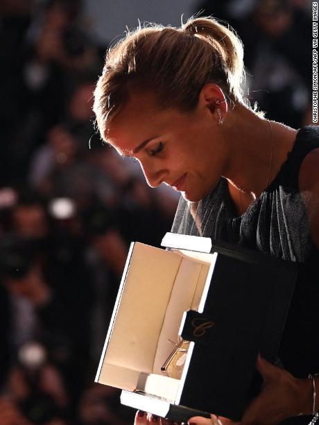 French director Julia Ducournau looks at her trophy as she poses during a photocall after she won the Palme d&#39;Or for the film &quot;Titane&quot; during the closing ceremony of the 74th edition of the Cannes Film Festival in Cannes, southern France, on July 17, 2021. (Photo by CHRISTOPHE SIMON / AFP) (Photo by CHRISTOPHE SIMON/AFP via Getty Images)