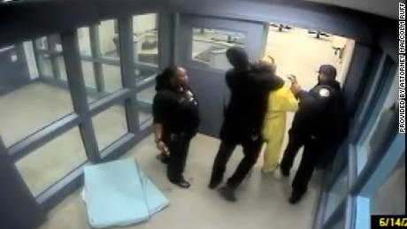 A frame grab from security video provided by attorney Malcolm Ruff shows Amber Canter, in yellow, being held by a corrections officer in what Ruff says was an illegal chokehold.