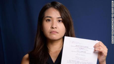 Pro-democracy activist Gwyneth Ho, who was banned from standing in upcoming local elections, poses with her disqualification notice at her office in Hong Kong on August 4, 2020. 