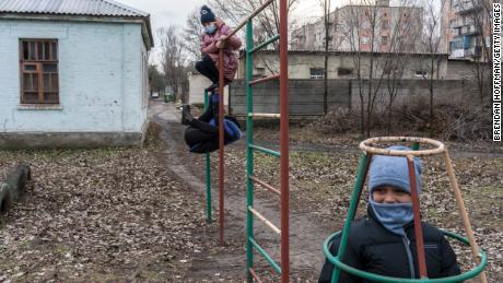 Учащиеся школы № 5 играют на детской площадке в ожидании автобуса, который закончит школу, 8 декабря 2021 года в Красноровке, Украина. 