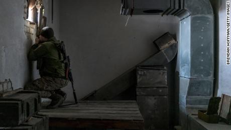     كوليا ، جندي أوكراني ، يستخدم منظارًا يدويًا لمشاهدة مواقع القوات المدعومة من روسيا من مبنى على خط المواجهة في 8 ديسمبر 2021 في مارينكا ، أوكرانيا. 