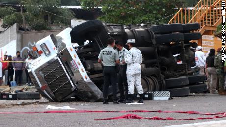 افسران گارد ملی مکزیک در منطقه ای که کامیون واژگون شد کار می کنند.