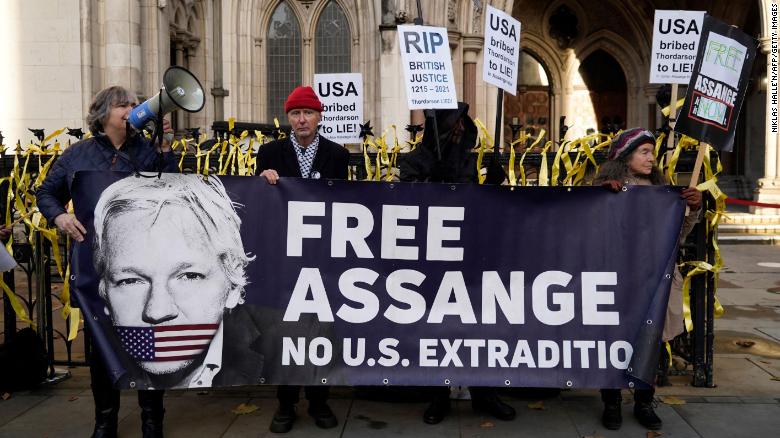Unterstützer des WikiLeaks-Gründers Julian Assange halten am 10. Dezember 2021 Plakate vor den Royal Courts of Justice in London.