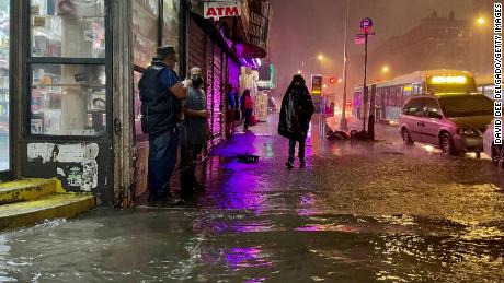 New Yorkers wade through flooded streets brought by extreme rainfall from the remnants of Hurricane Ida on September 2021, in the Bronx borough of New York City. 