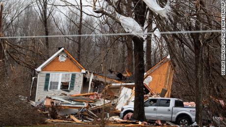 Residents survey damage from the overnight storm that tore through their communities Saturday, in Dickson County, Tennessee. 