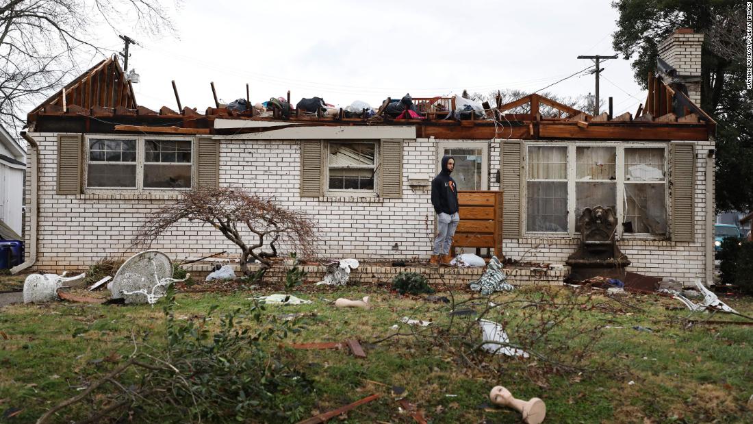 A person stands among the damage and debris in Bowling Green on Saturday, December 11.