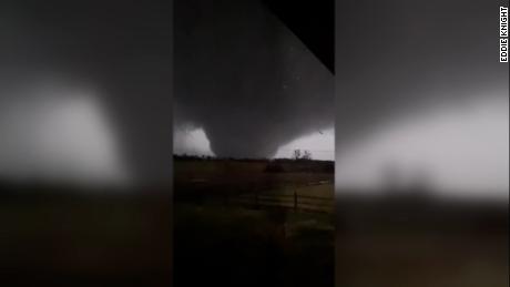 Lightning flashes in dark sky illuminate massive tornado