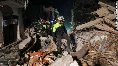 A rescue team searches for missing residents after a four-storey building collapsed following a gas explosion.