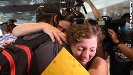 A family reunites at Brisbane&#39;s domestic terminal after the first flight from Melbourne since border restrictions have eased on December 13.