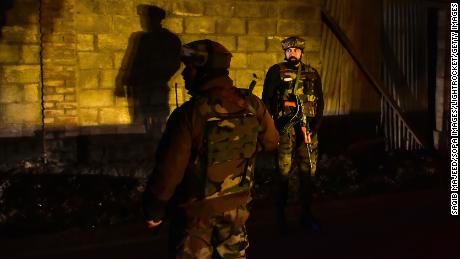 Paramilitary troopers stand guard at the site of an attack on the outskirts of Srinagar on December 13.