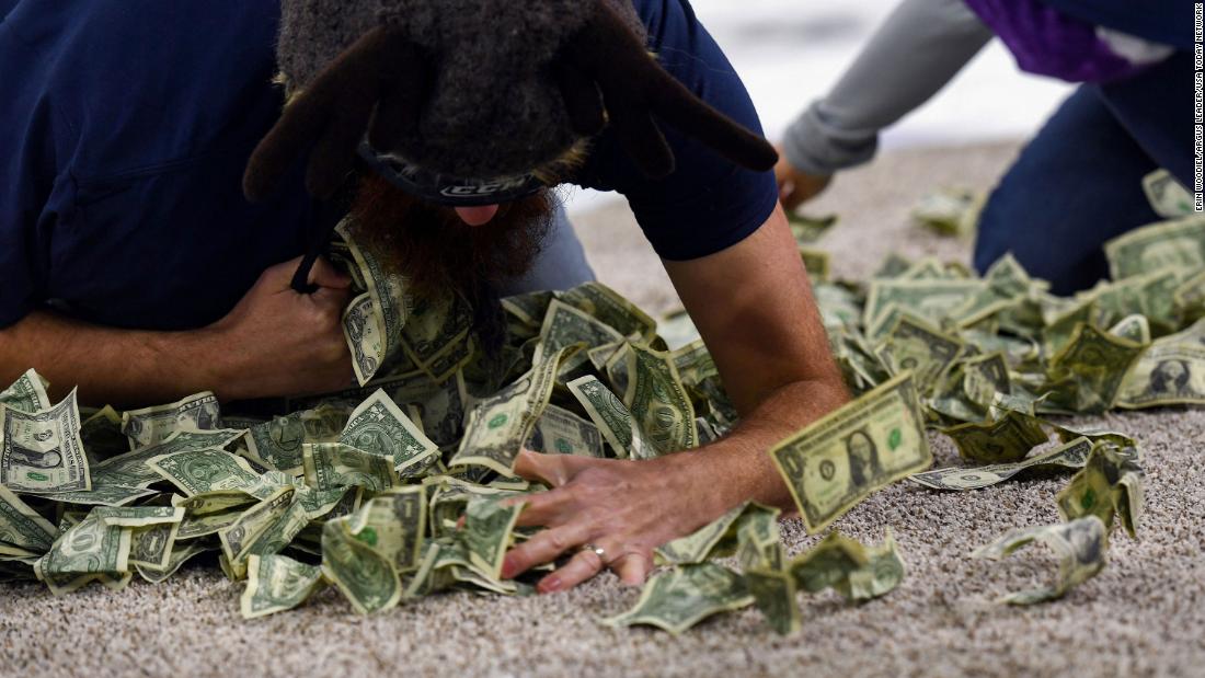 A giveaway at a hockey game saw schoolteachers scrambling on their knees to grab fistfuls of cash. Organizers are apologizing