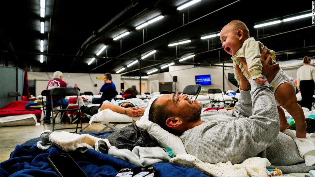 Anthony Vasquez plays with his 4-month-old son, Michael, inside a makeshift shelter in Wingo, Kentucky, on December 13.