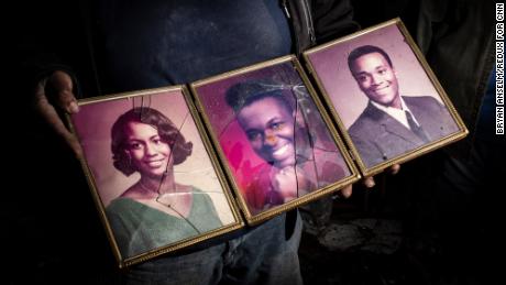 Jason White holds family photos he salvaged from his home in Mayfield, Kentucky.